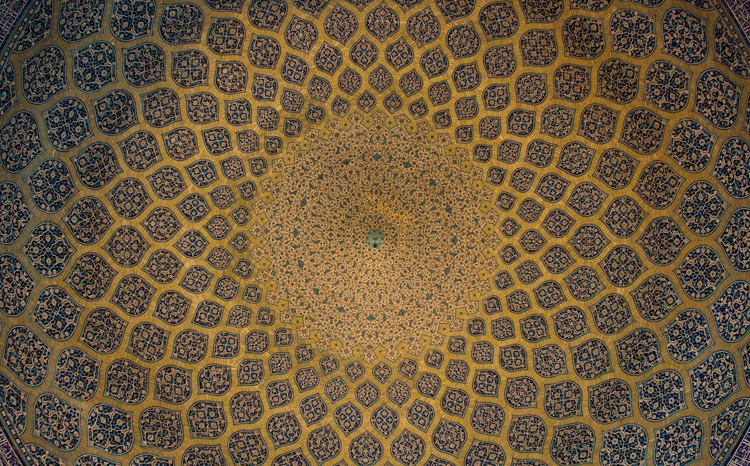 زخارف هندسية إسلامية زرقاء وذهبية على قبة معمارية